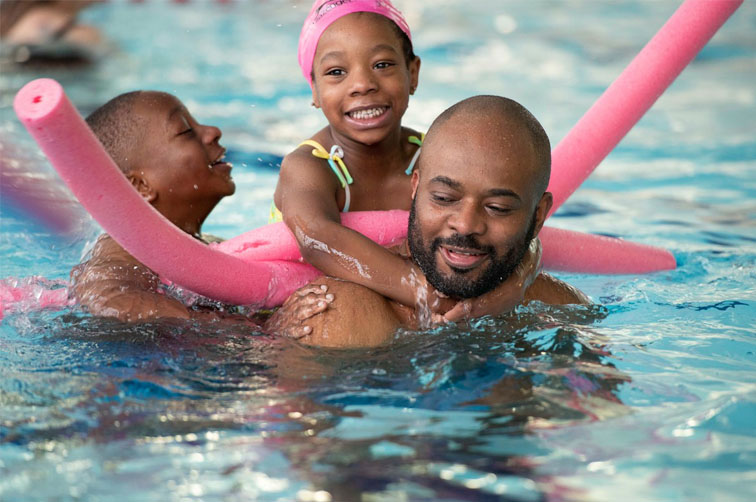 Happy family swimming together